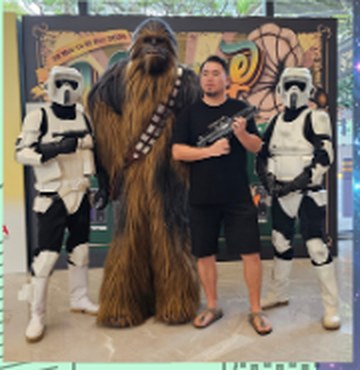 Two stormtroopers and a Chewbacca costume posing with a visitor
