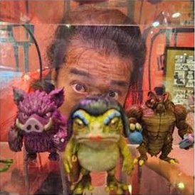 Collectible toy figures by Mox Monsters, with the maker peeking over them